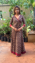 Full-length view of black block print long dress with maroon contrast hem