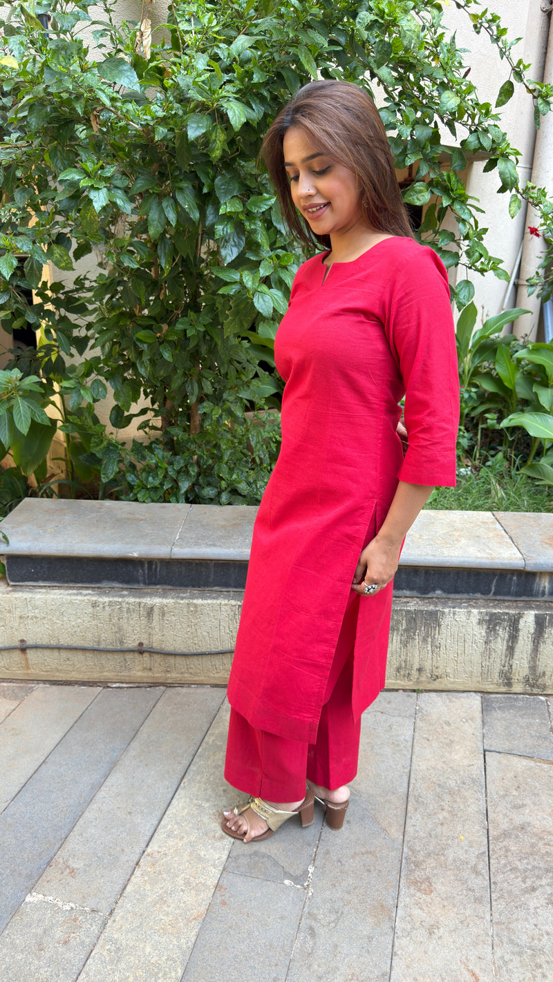Front view of the straight-cut red cotton kurta set styled with gold flat sandals.