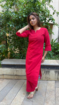 Model in red kurta set walking through outdoor setting