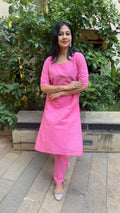 Model in pink kurta walking through outdoor space