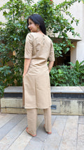 Full-length view of beige plain kurta set in natural light