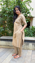 Model in beige kurta walking through outdoor space