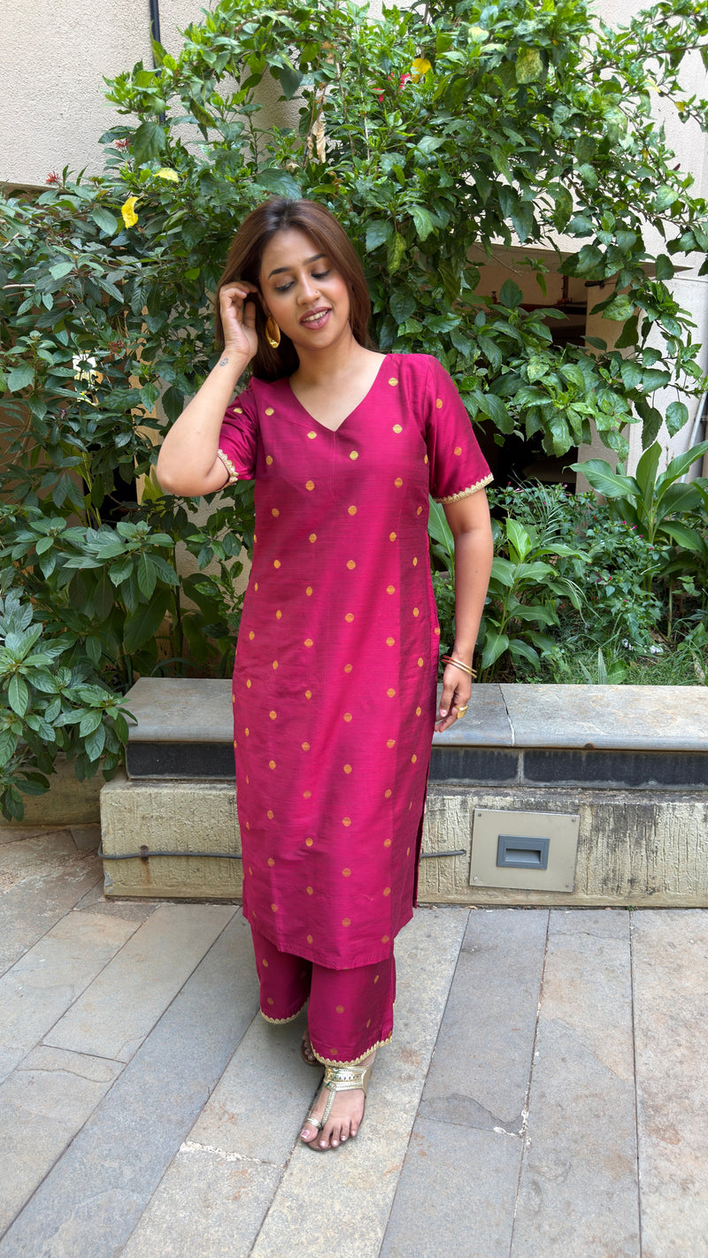 Detailed shot of the magenta polka dot slub silk kurta set highlighting the round neckline and gold accents.