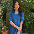 Full view from the front of the steel blue cotton kurta set paired with brown flat sandals.