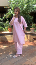 Detail of subtle tonal motifs on light pink cotton