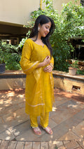 Three-quarter view of yellow organza kurta set in natural light