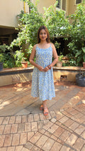Three-quarter view of white cotton calf-length dress with blue buti print
