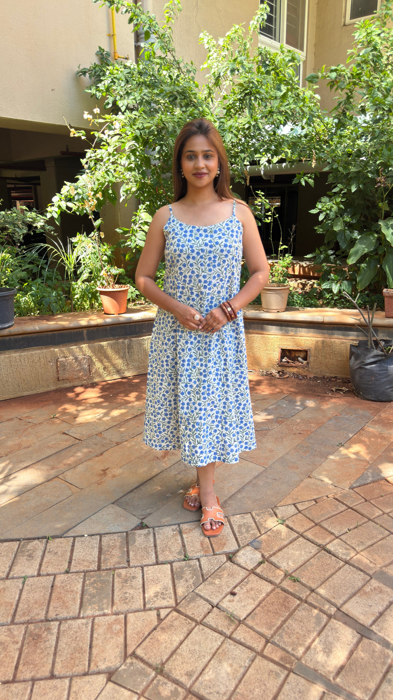 Three-quarter view of white cotton calf-length dress with blue buti print