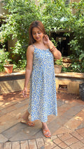 Side view of sleeveless blue block print midi dress showing easy drape