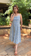 Close-up of slim strap and scoop neckline on white block print cotton dress