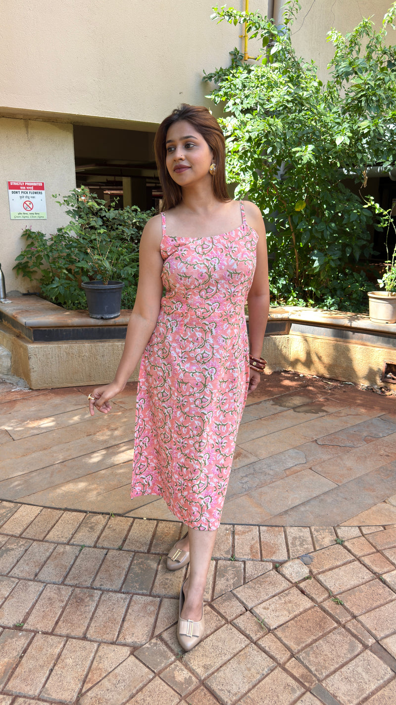 Front view of pink floral block print calf-length dress with slim straps