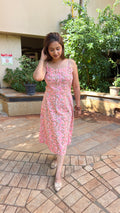 Model in pink summer dress walking through outdoor setting