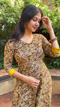 Three-quarter view of olive handloom cotton dress with mustard contrast cuffs