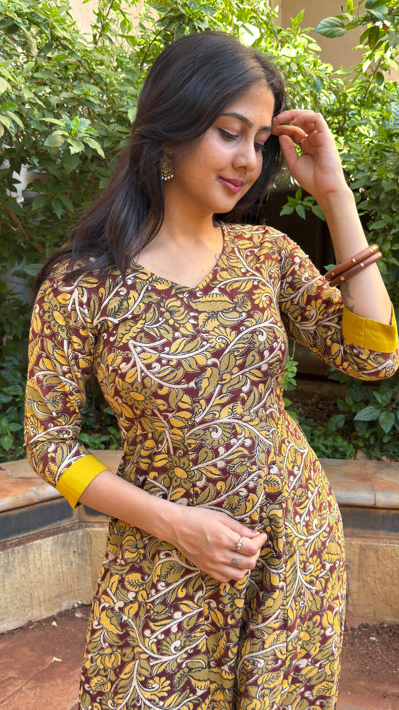 Three-quarter view of olive handloom cotton dress with mustard contrast cuffs