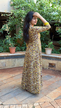 Close-up of mustard floral motifs on olive cotton, showing handwork irregularities