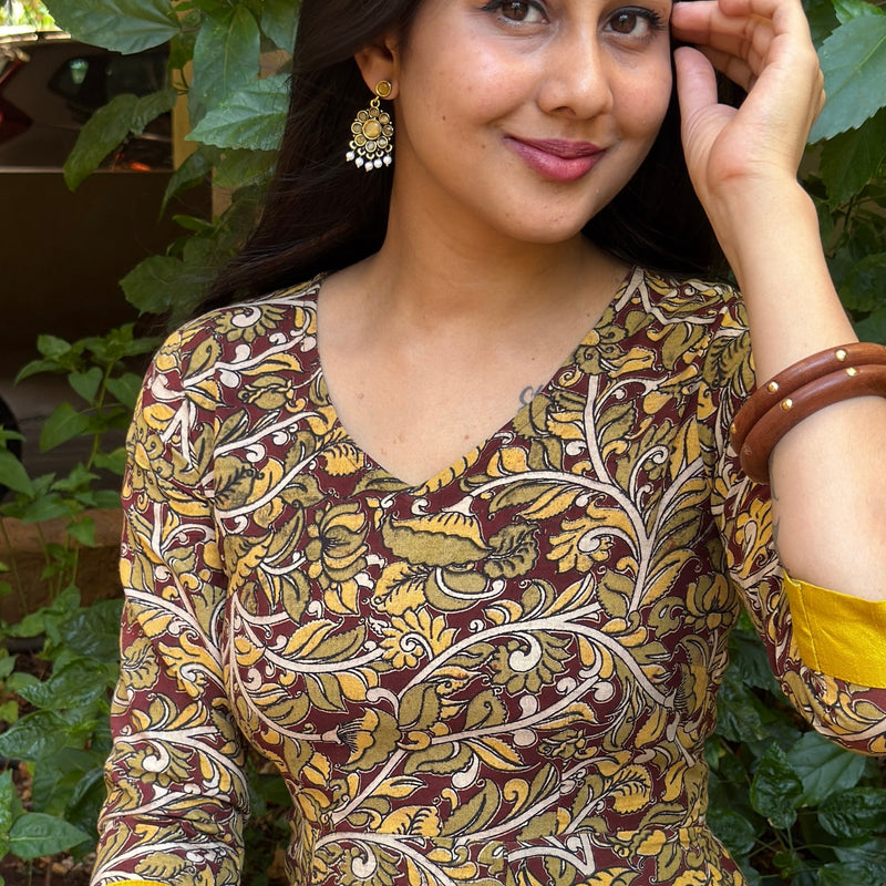 Portrait of a woman wearing the olive yellow cotton long dress with traditional wooden bangles.