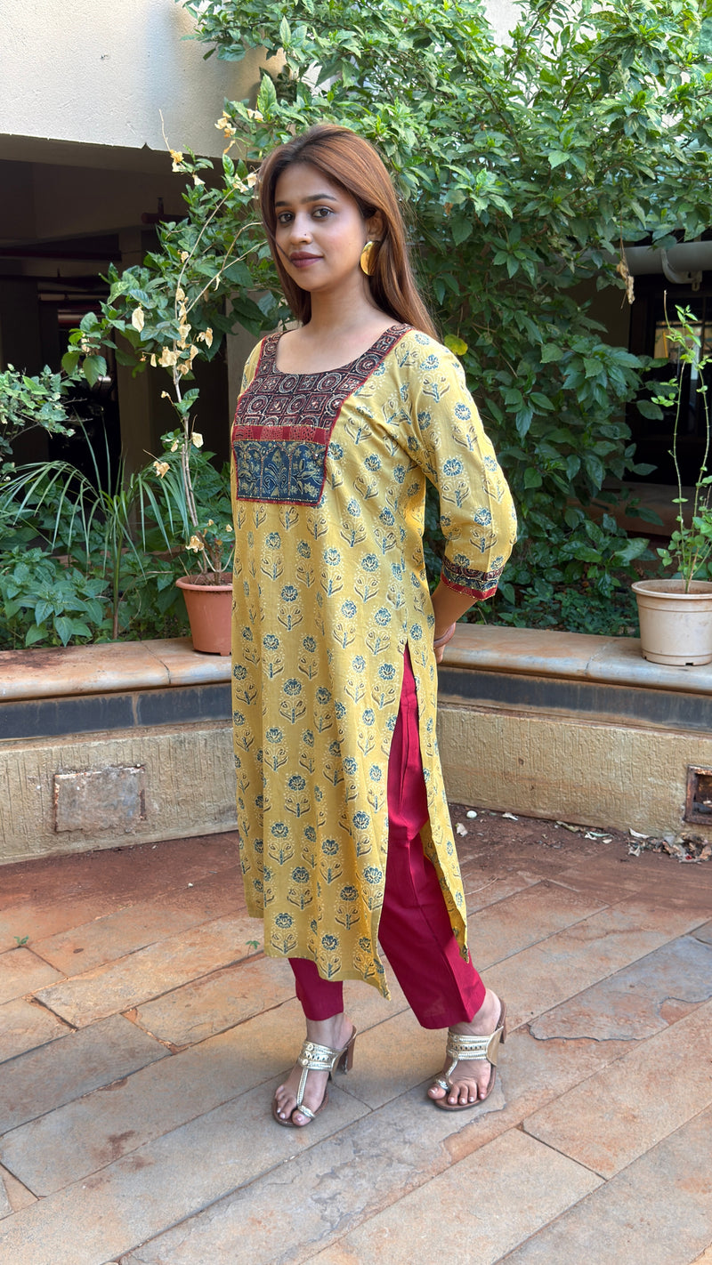 Front view of yellow Ajrakh kurta showing maroon yoke and sleeve cuff trim