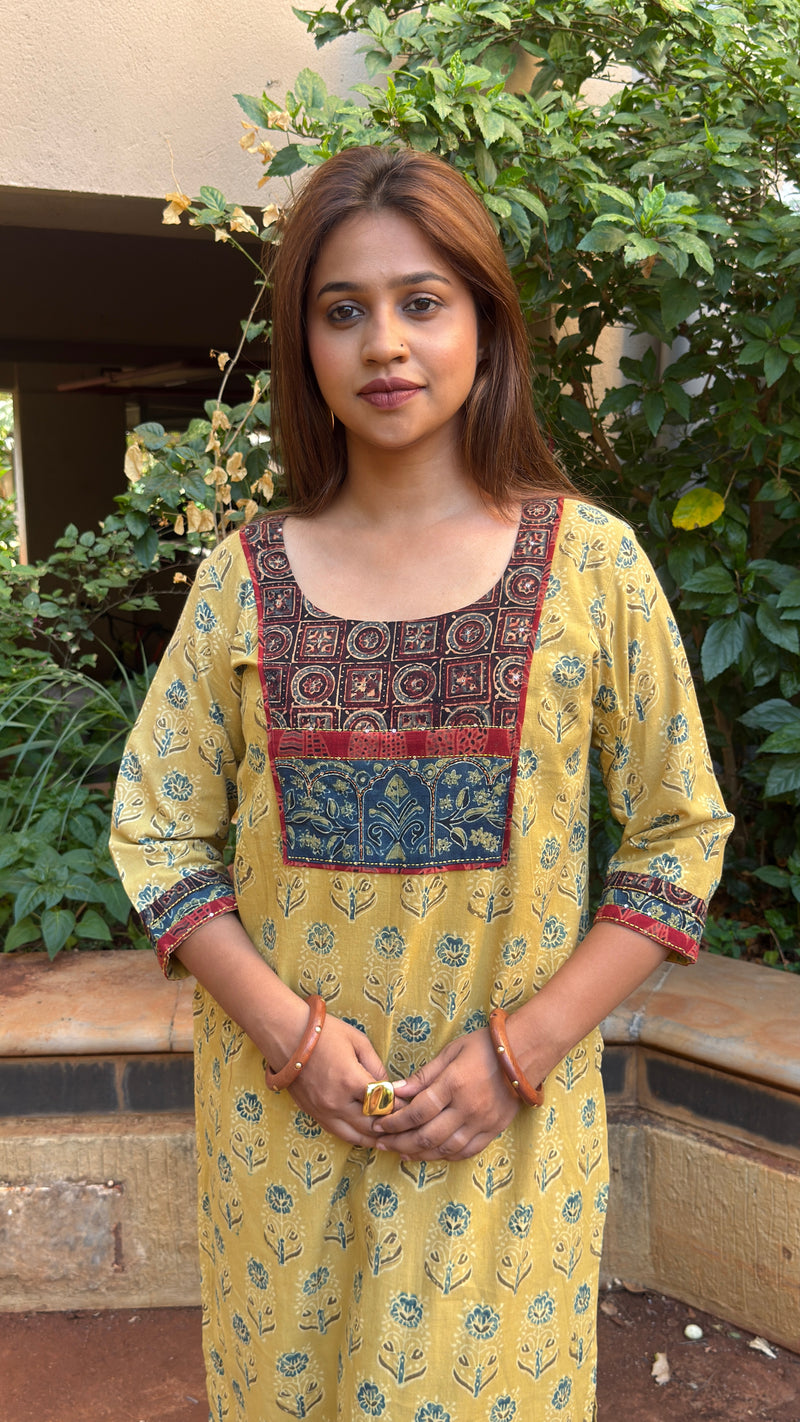 Three-quarter view of yellow Ajrakh print kurta with maroon pants