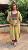 Model in yellow Ajrakh kurta walking through outdoor space