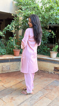 Detail of V-neckline and sleeve cuff trim on pink cotton kurta