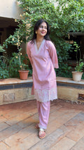 Close-up of cutwork embroidery on pink cotton