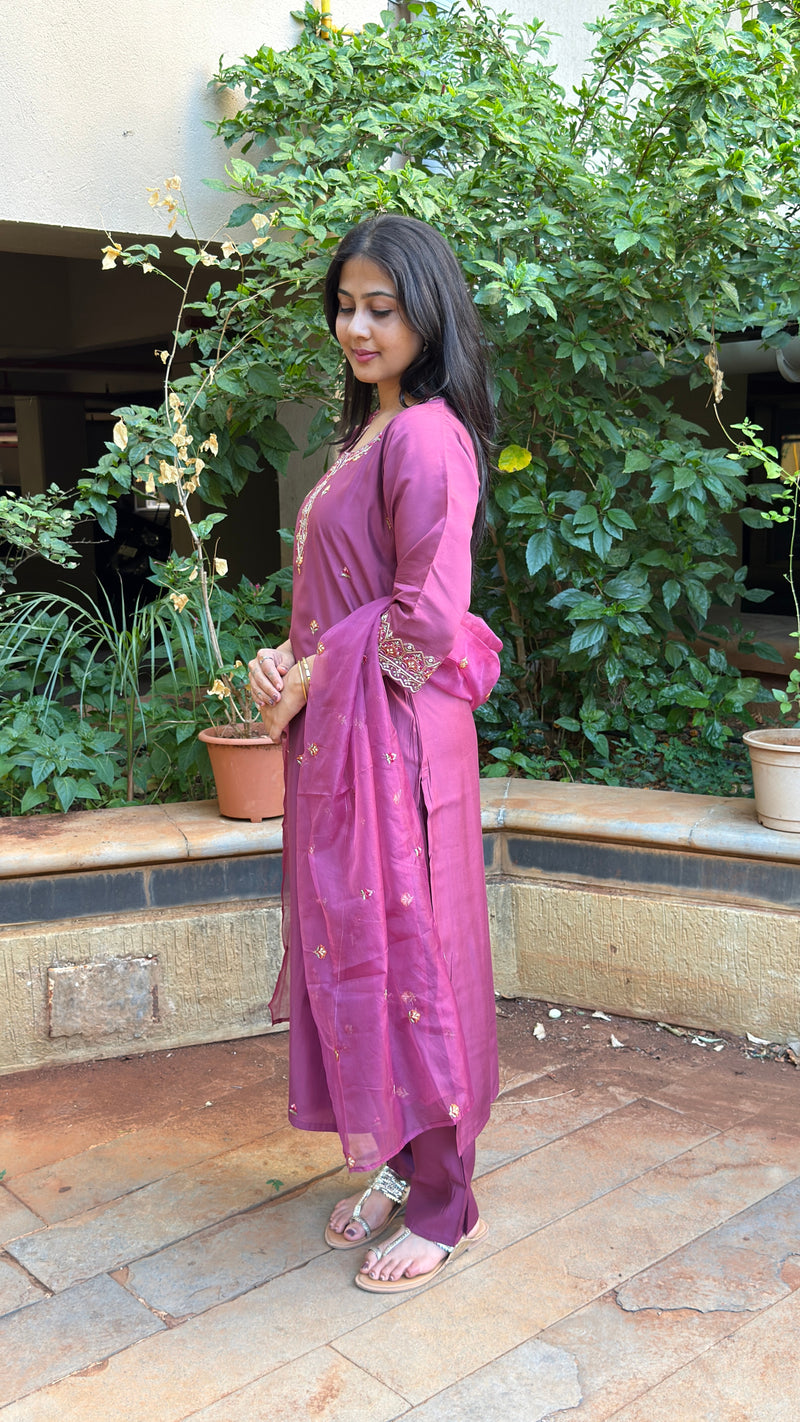 Medium shot of a woman wearing a mauve cotton-silk kurta set, focusing on the three-quarter sleeves and subtle floral print.