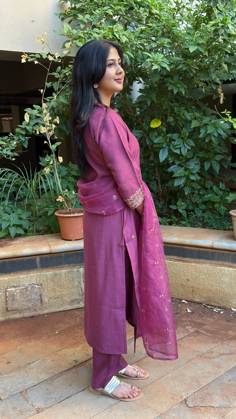 Close up of the hem and lower body of a woman wearing a mauve cotton-silk kurta set with matching straight trousers.