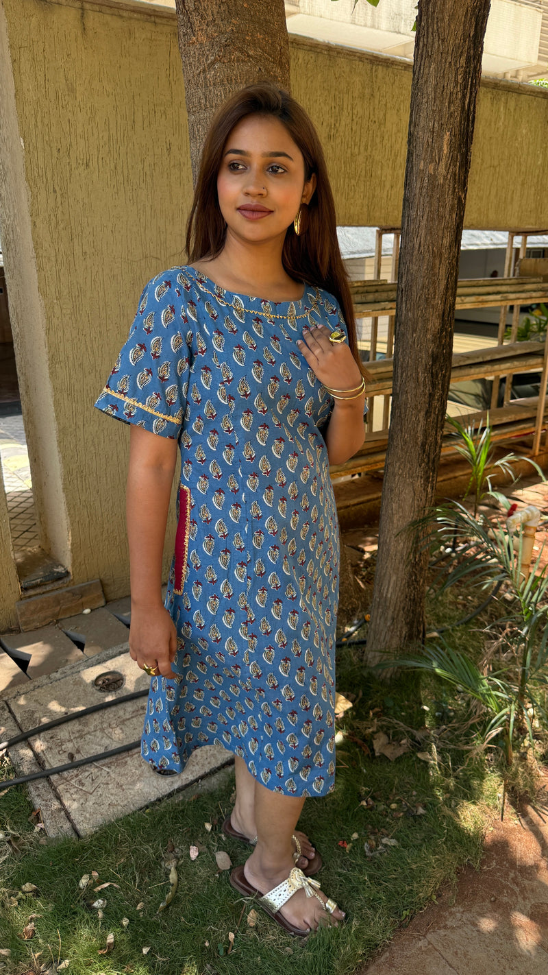 Side view of blue block print midi dress with elbow sleeves and gilded trim