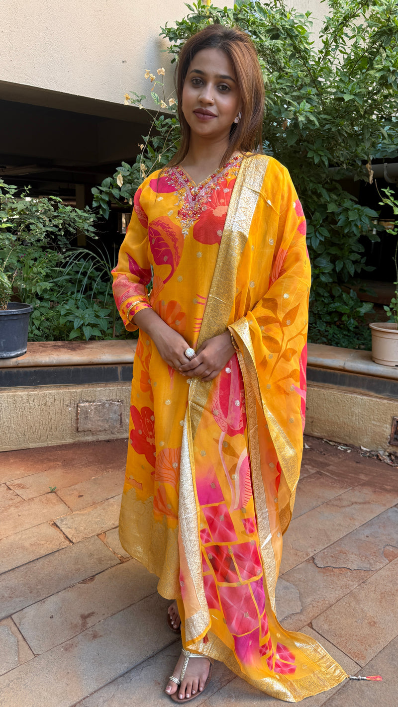 Three-quarter view of yellow organza kurta set with gold-bordered dupatta