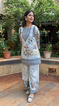 Three-quarter view of ivory short kurta set in crape fabric