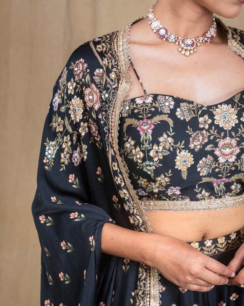 Model posing in black floral printed Indo-Western cape dress with hands on waist
