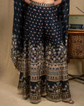 Standing view of a three-piece black floral modal cape set with flared leg pants