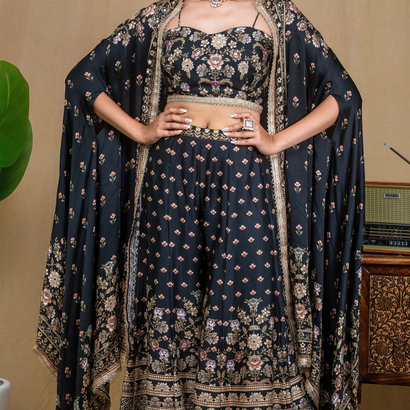 Model wearing a black floral modal cape set standing next to a vintage carved table
