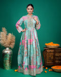 Mid-shot view highlighting hands on waist in a sea green multi-print flared georgette dress with fitted waist.