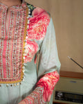 Close-up of the long sleeves with detailed floral embroidery and sequin trim on sea green georgette fabric.