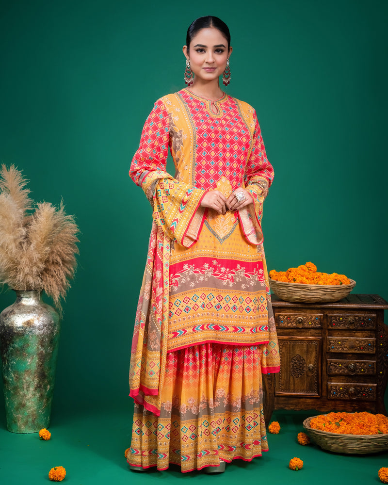 Model wearing a coral and yellow printed georgette sharara set with flared bell sleeves.