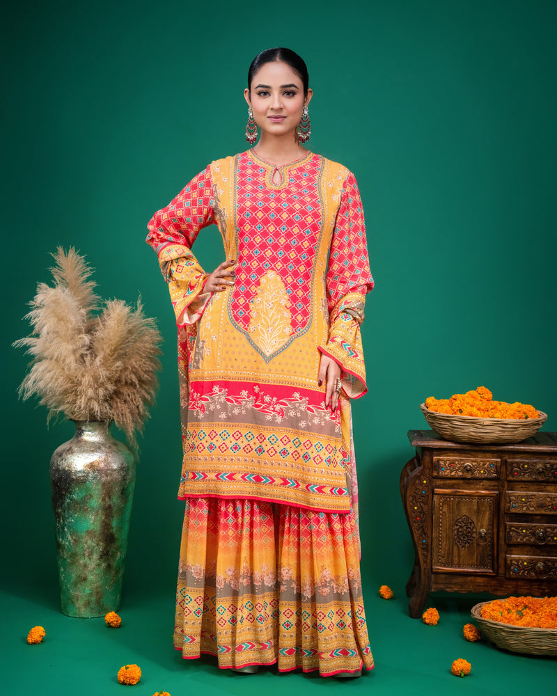 Full-length front view of yellow and red printed sharara set with draped dupatta.