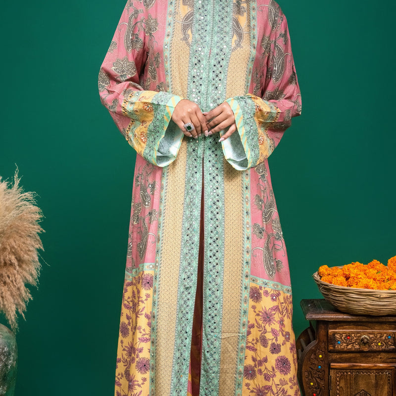 Full length shot of model styled in pink and yellow modal Indo-western dress with green drop earrings