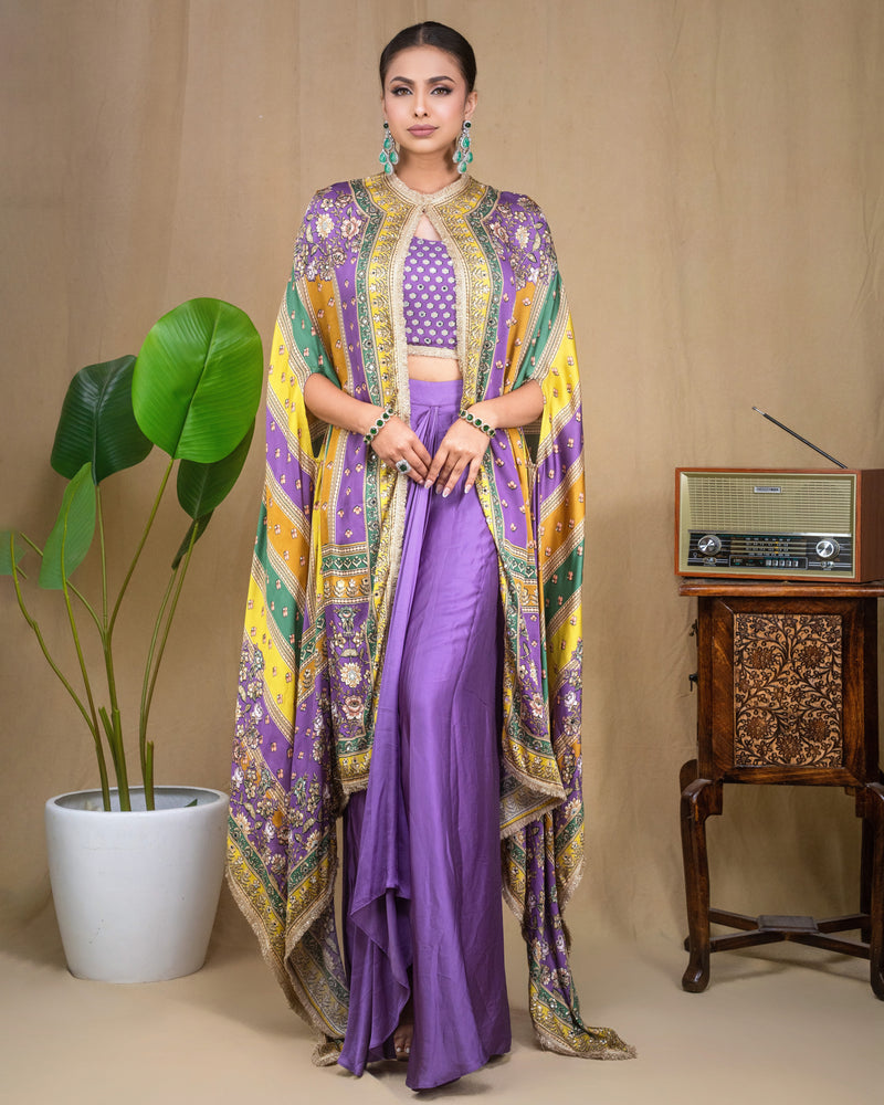 Close-up of purple hand-embroidered crop top with mirror work and multi-colored printed cape overlay.