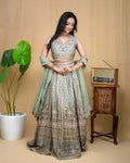 Detailed view of hand embroidered floral motifs and mirror work on a sage green modal skirt.