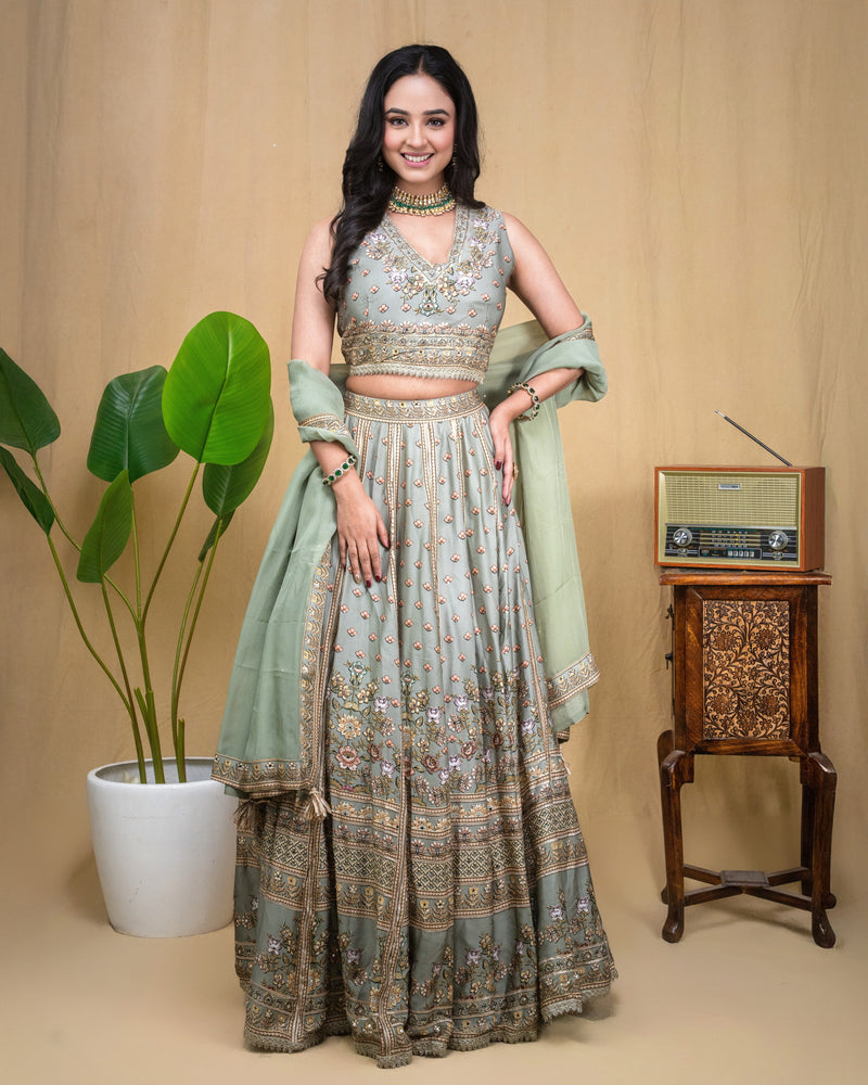 Back view of the sage green modal hand embroidered crop top and flowing lehenga skirt set.