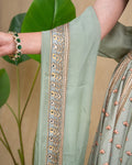 Side profile showing the fit and sleeveless silhouette of the sage green modal lehenga top.
