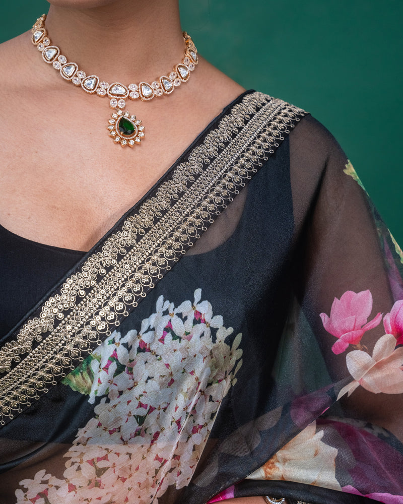 Close-up of the pleats on a black organza saree adorned with pink floral motifs