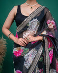 Styling detail of green emerald jewelry paired with a black floral organza saree