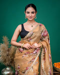 Front pose of model showcasing the fluid drape of a beige organza saree with floral motifs.