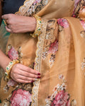 Mid section detail of beige organza saree highlighting the delicate rose print and pleats.